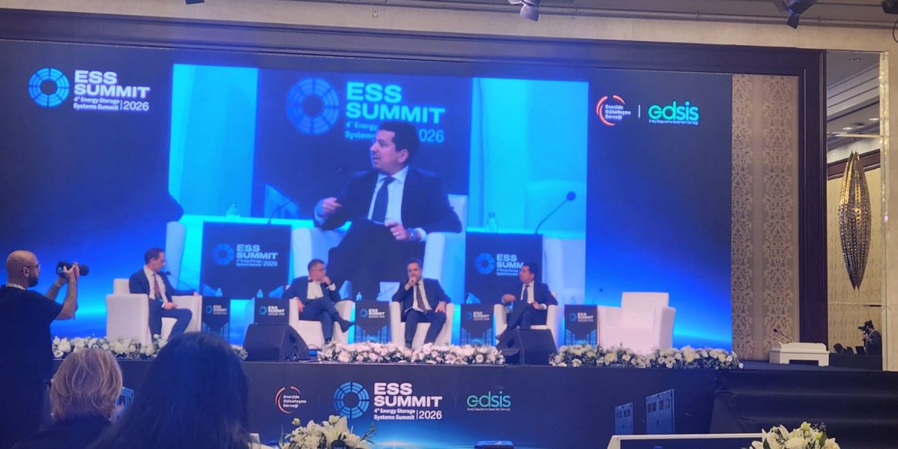 Volkan Yiğit on stage during an ESS Summit 2026 panel, also shown on the large screen behind the speakers
