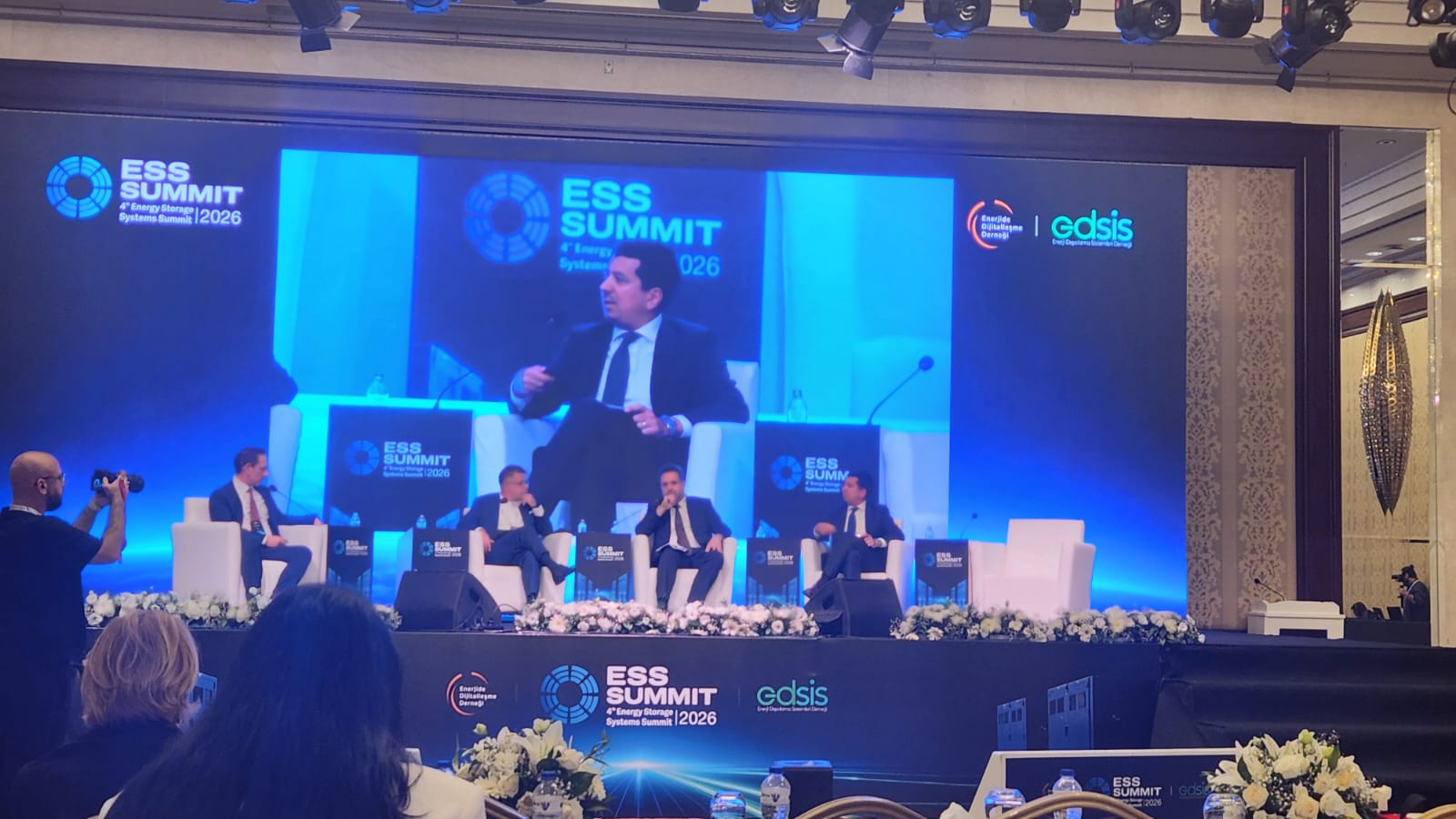 ESS Summit 2026 panelinde yer alan Volkan Yiğit’in sahnede ve arkasındaki büyük ekranda göründüğü fotoğraf